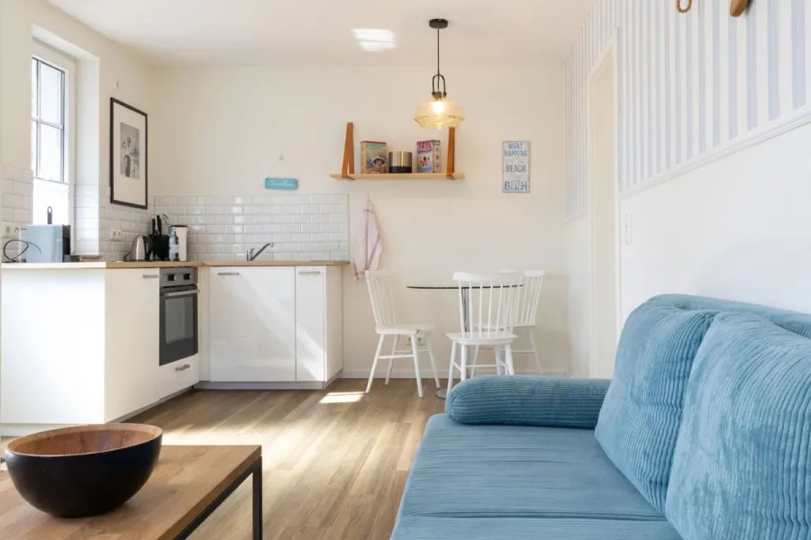 Helles Apartment im Boutique-Hotel STRANDHAUS Ahrenshoop auf dem Fischland-Darß-Zingst mit Wohnküche und Sitzbereich.