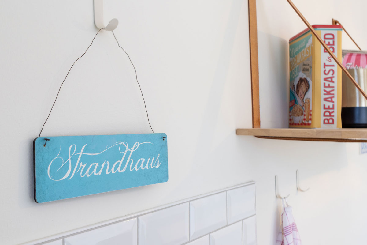Türschild mit Schriftzug Strandhaus in der Küche des Apartments im STRANDHAUS Ahrenshoop.