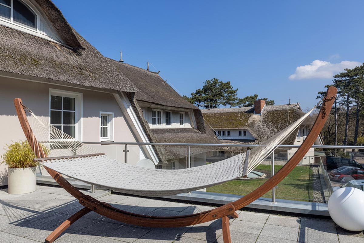 Hängematte auf dem Sonnendeck des STRANDHAUS Ahrenshoop mit Blick auf die Reetdächer von Ahrenshoop.
